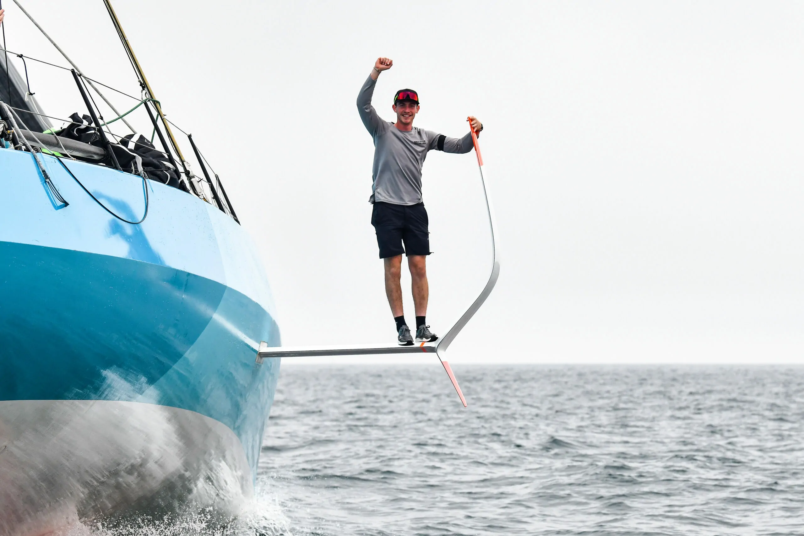 A man waving from a yacht that he is stood on the side of. An example of who we help through our blog.