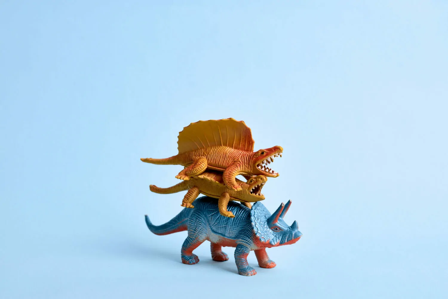 Three toy dinosaurs stacked on top of each other with a blue background. Accounting advice