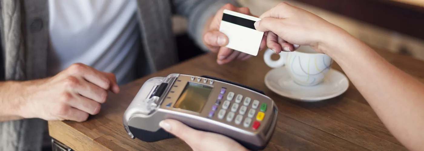 Someone making a transaction while they explain the new credit card rules