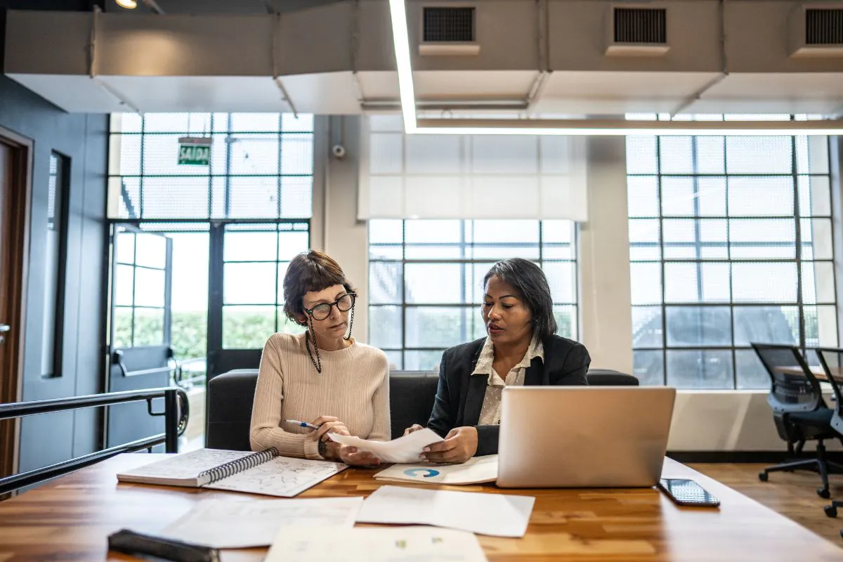 Two people discussing how much a fractional CFO costs sat at a laptop