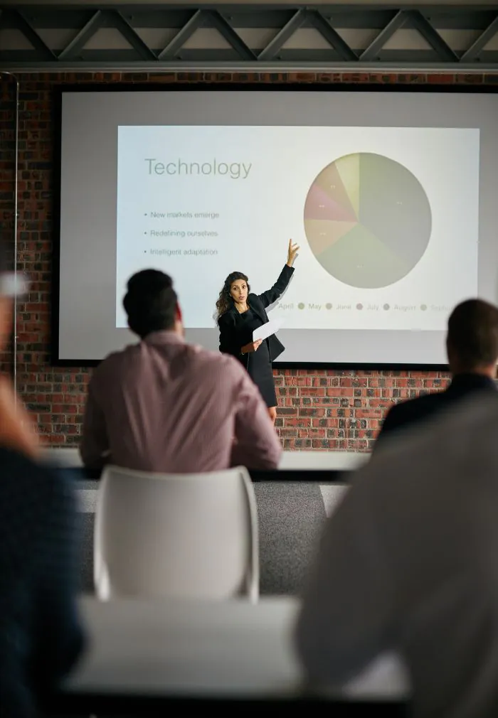 Women presenting in front of a whiteboard to help raise investment